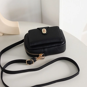 Macro detail of lychee textured leather phone bag with gold clasp and fine stitching