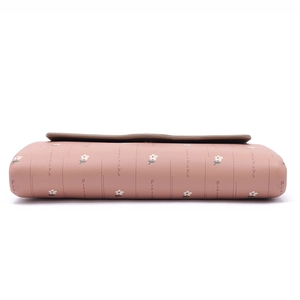 Detail of pink long wallet featuring daisy floral print and Prettyzys brand logo