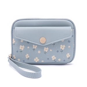 Détail du protège-passeport bleu clair à fleurs avec bouton doré embossé du logo