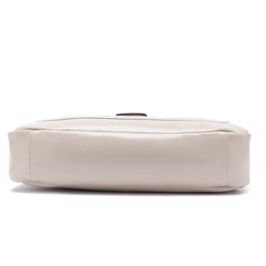 Vue détaillée du dessous du sac en cuir beige montrant les coutures précises et la base