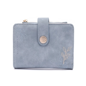 Detail of light blue faux leather wallet with leaf embroidery and golden snap closure