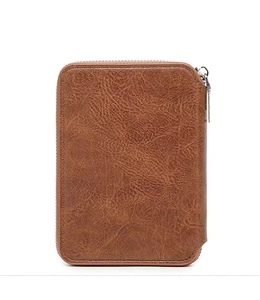 Macro detail of brown textured leather passport wallet with vintage grain and silver zipper