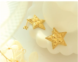Detail of gold star earrings with quilted texture and beaded edges in a retro style