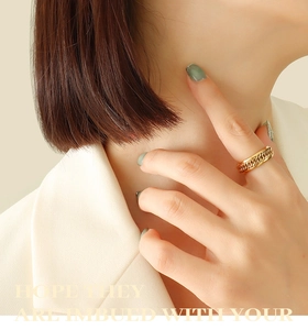 Close-up of triple-layered 18k gold-plated titanium steel ring with braided texture