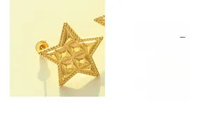 Macro shot of 18k gold plated star stud earrings showing 3D faceted relief craftsmanship