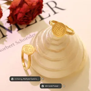 Minimalist 18k gold plated stainless steel ring with Fu character on white display stand