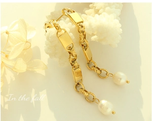 Macro detail of vintage gold chain earrings with natural freshwater pearls and geometric links