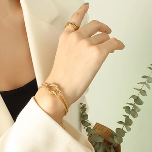 Gold-plated knot-design braided bracelet and Cuban link ring set worn by female model