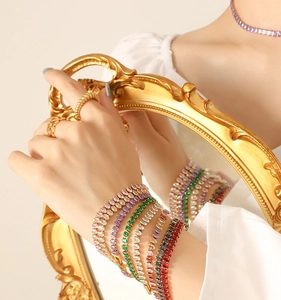 Detailed shot of gold bracelets with colorful oval gemstones on a vintage frame