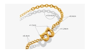 Detail of gold-plated Cuban chain bracelet with bamboo textured letter B pendant