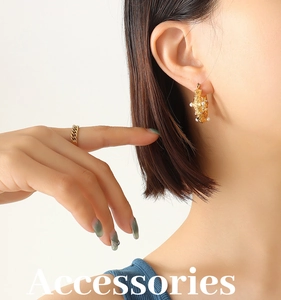 Detailed view of hammered gold U-shape earrings with inlaid pearls on model's ear