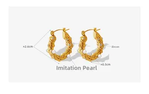 Detail of hammered gold U-shape earrings with inlaid imitation pearls and zircons