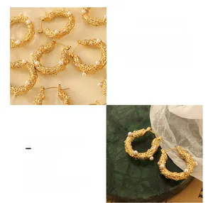 Detail of hammered gold U-shaped hoop earrings with imitation pearls and white zircons
