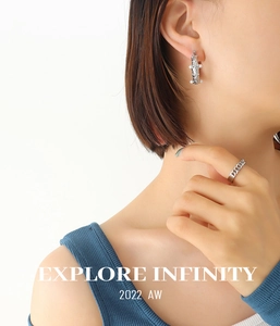 Detail of silver hammered U-shape earring with pearl and matching link ring on a model