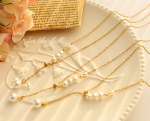 Detailed view of elegant gold pearl necklaces on a vintage white decorative plate
