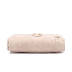 Detail of beige suede long wallet with leaf embroidery and metal snap button closure
