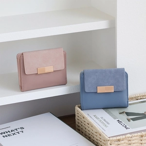 Detail of short leather wallets with gold metal buckle and textured matte stitching