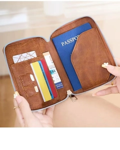 Detail of brown leather passport holder showing card slots and zipper compartment