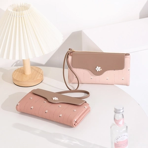 Detail of floral long wallet with patchwork design and pink leather wristlet strap