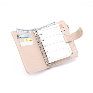 Detail of A6 binder wallet showing 6-hole metal rings, card slots, and zipper pocket