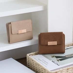 Detail of short PU leather wallets with gold buckles in beige and brown colors