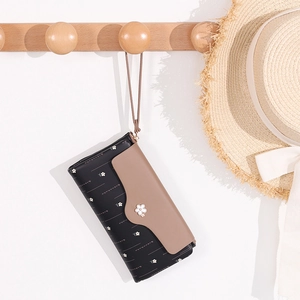 Detail of floral printed long wallet with wrist strap hanging on a wooden hook