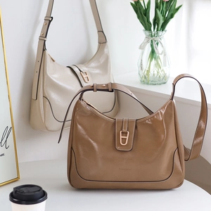 Détail de sacs hobo en forme de lune beige et marron avec boucle et bandoulière