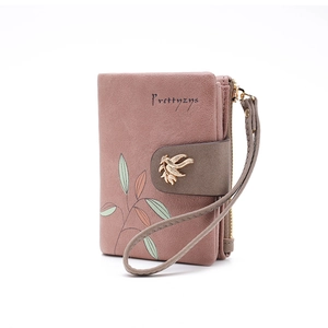 Close-up of pink PU leather wallet featuring leaf print and metal bird clasp detail