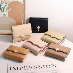 Short tri-fold wallets in multiple colors with floral pendants and gold cloud buckles
