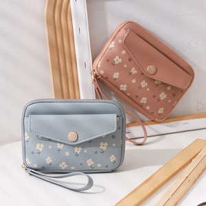 Detail of floral mini passport wallets with gold leaf buckles and convenient hand straps