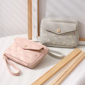 Floral print passport bag detail with magnetic leaf buckle and wrist strap