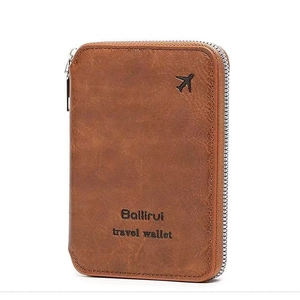 Close-up of brown vintage leather travel wallet with zipper and airplane embossing