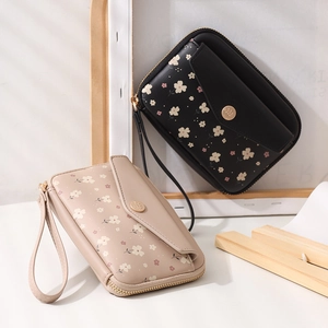 Detailed view of floral pattern wristlet purses with leather texture and zip closure