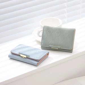Detail of rhombic textured trifold wallets in green and blue with snap closure