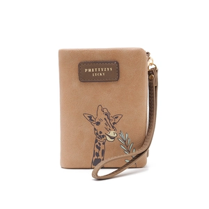 Macro shot of brown faux leather coin purse featuring a giraffe print and wrist strap