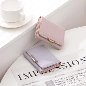 Detailed view of quilted tri-fold wallets in pastel pink and purple with magnetic buckles