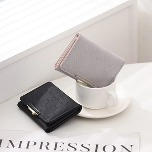Close-up of quilted tri-fold wallets with hexagonal pattern and gold buckle detailing