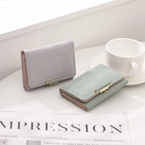 Detail of trifold wallets with hexagon textured faux leather and gold metal buckle
