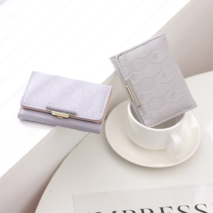 Close-up of diamond lattice textured PU leather trifold wallets with gold metal clasps