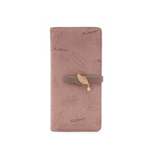Detail of pink PU leather wallet with leaf print and a golden metal leaf pendant charm