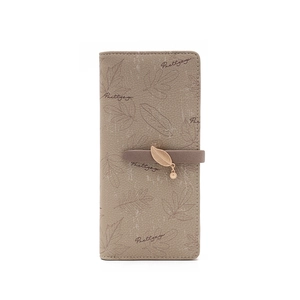 Detail of khaki long wallet with leaf print, brand logo and golden leaf metal pendant