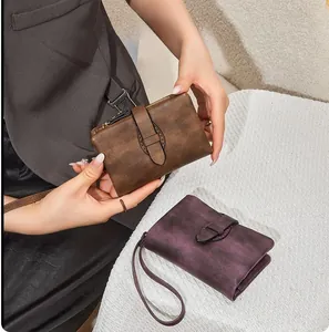 Detailed view of vintage faux leather wallets in brown and purple with secure buckle straps