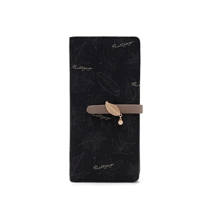 Close-up of long black wallet featuring grey leaf patterns and golden leaf charm zipper