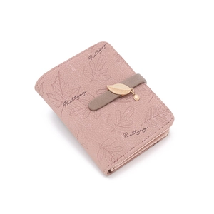Close-up of pink litchi leather wallet with golden leaf pendant and card slots