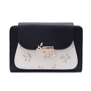 Detail of floral wallet with black and white lychee leather and gold leaf charm