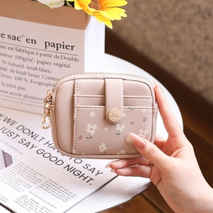 Close-up of floral print pink wallet featuring card slots and leaf-shaped snap button