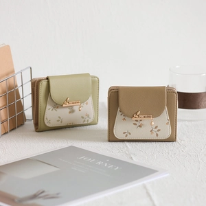 Detail of PU leather folding wallets with floral patterns and gold leaf clasps