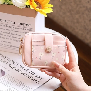 Close-up of pink floral pattern card wallet held in hand with card slots and snap button