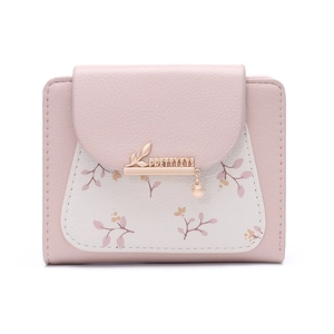 Dettaglio portafoglio in pelle rosa e beige con stampa floreale e ciondolo a foglia