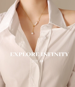 Detailed view of an elegant Y-shaped gold pearl necklace on a model wearing white